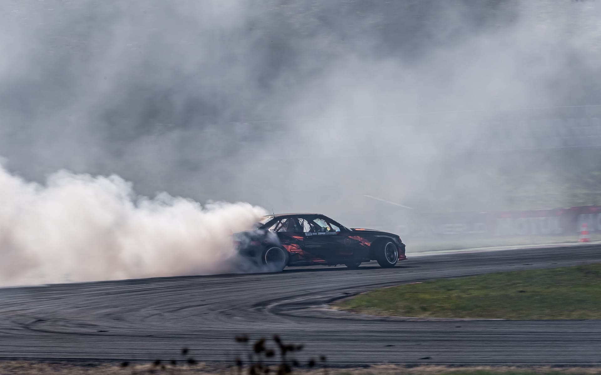 BMW E36 driftujące bokiem w chmurze dymu z opon